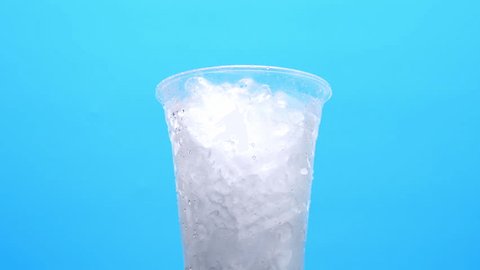 Pour black coffee into a glass isolated on blue background, coffee art. Stock Video