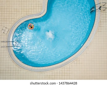 Aerial drone picture about a beautiful, blue ,outdoor swimming pool with playing children. Stock Photo